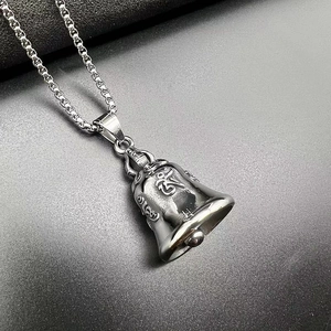 Macro view of stainless steel biker bell pendant with Sanskrit Om engraving and box chain