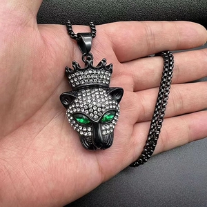 Détail du pendentif tête de léopard hip hop avec couronne et yeux en pierres vertes