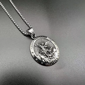 Vue macro du pendentif relief Saint-Michel avec devise protectrice gravée sur chaîne
