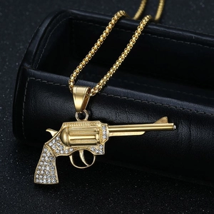 Detail einer Hip-Hop-Revolver-Halskette mit funkelnden Zirkonia auf schwarzem Leder
