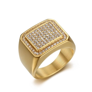 Détail macro d'une bague chevalière hip hop dorée pour homme avec cristaux rectangles