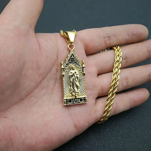 Macro shot of gold-plated gothic arch religious pendant with Mary relief on rope chain