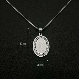 Detail showing 43mm x 23mm silver oval religious pendant with crystals on black background