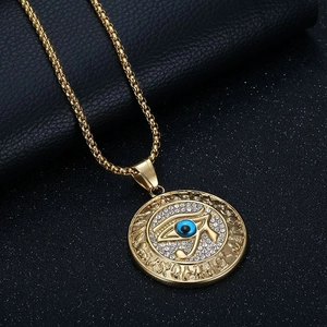 Gold Eye of Horus hip hop pendant with sparkling crystals on black leather backdrop