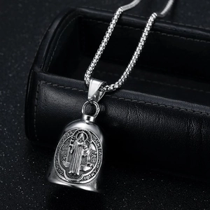 Detailed close-up of Saint Benedict bell pendant with intricate religious engravings