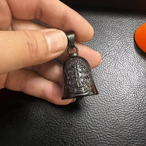 Detailed view of Saint Benedict Medal engraving on black matte stainless steel bell pendant
