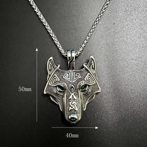 Close-up of Viking wolf head necklace featuring green gemstone eyes and 50mm height