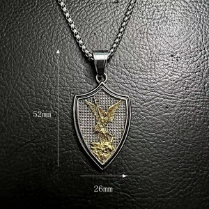 Macro shot of gold St. Michael archangel shield pendant measuring 52mm by 26mm