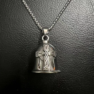 Detail showing vintage titanium steel Viking cross bell pendant with ornate engravings