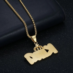 Macro shot of gold DAISY letter pendant with crown detail on black leather background