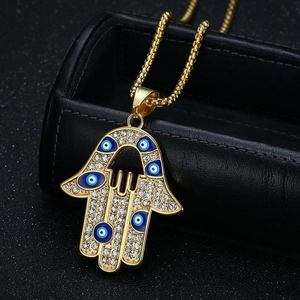 Collier Main de Fatima doré avec motifs Oeil Bleu et strass étincelants sur fond sombre
