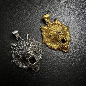 Detailed relief of gold and silver Viking wolf head pendants on black leather background