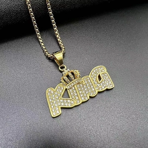 Macro detail of gold-plated KING crown pendant with sparkling pave zircon stones