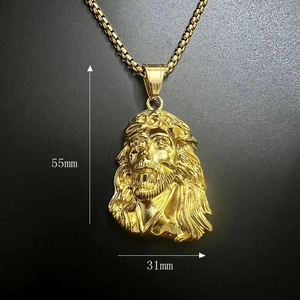 Macro shot of 55x31mm gold-plated Jesus pendant with box chain on black texture