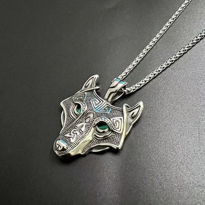 Macro view of Viking wolf pendant with green zircon eyes and blue enamel accents