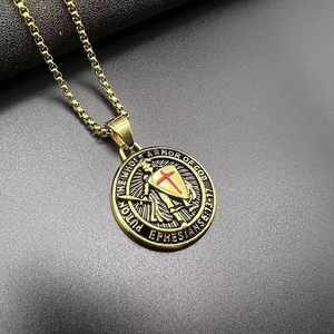 Vue macro du pendentif de templier plaqué or avec croix rouge et versets bibliques