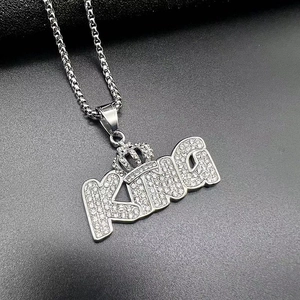Macro shot of silver hip-hop KING pendant with crown and paved cubic zirconia stones