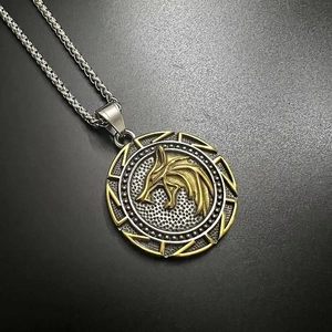 Macro detail of Viking wolf head pendant with golden relief on stainless steel chain