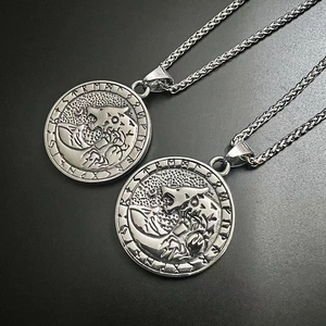 Detailed view of silver Viking wolf head pendant with Nordic runes on woven chain