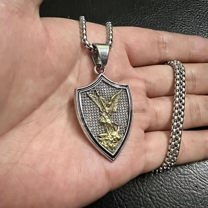Macro shot of St. Michael shield pendant necklace with gold angel relief on silver steel
