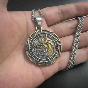 Detailed close-up of a masculine gold wolf head relief on a vintage steel medallion pendant