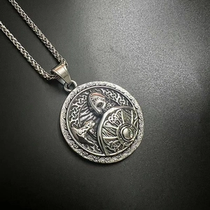 Vue macro d'un pendentif guerrier viking vintage avec bouclier et motifs nordiques