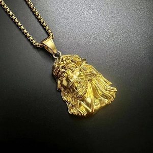 Macro close-up of gold-plated Jesus pendant with intricate thorns and box chain