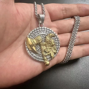 Detail of Viking raven and battle axe pendant showing embossed metal texture in hand