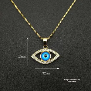 Dettaglio del grande ciondolo Evil Eye dorato con cristalli blu e dimensioni di 30mm x 32mm