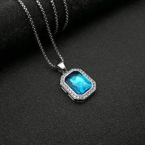 Primer plano detallado de un collar plateado con un colgante rectangular de gema azul