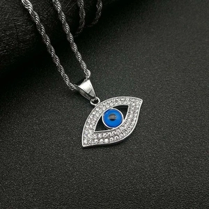Collier hip-hop œil porte-bonheur argenté avec cristaux brillants sur fond texturé sombre