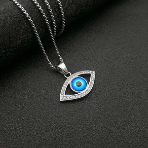 Macro di collana in argento con ciondolo occhio blu e cristalli su sfondo grigio scuro