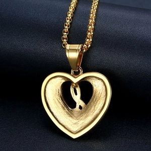 Polished gold plated heart pendant necklace with ribbon detail on a box chain