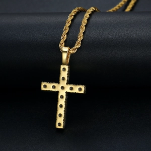 Macro shot of gold-plated cross pendant with black zircon inlays on a rope chain
