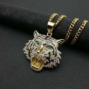 Close-up of hip hop tiger head pendant with white rhinestones and green gem eyes