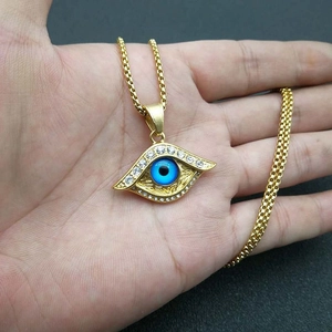 Vergoldete Edelstahl-Halskette mit Evil Eye Anhänger und Strasssteinen auf der Hand