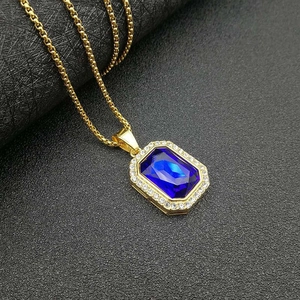 Primer plano de colgante con gema azul rectangular y borde de diamantes dorados