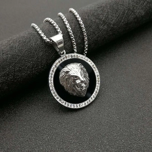 Gros plan du pendentif tête de lion hip hop argenté avec zircons et fond noir brillant