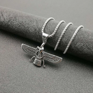 Detailansicht einer silbernen Faravahar-Flügelkette auf einer schwarzen Textursäule