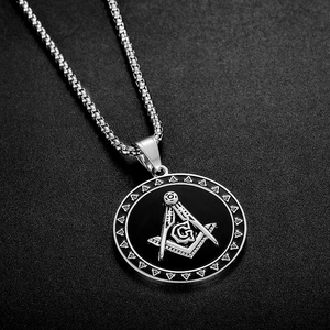 Macro view of silver stainless steel Freemason pendant with G logo and box chain