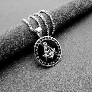 Close-up of silver steel Masonic AG pendant with black inlay on a round pearl chain