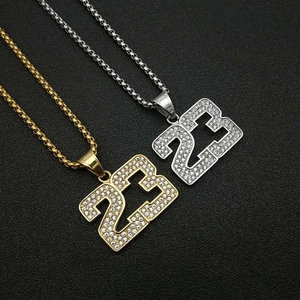 Gros plan de pendentifs hip hop chiffre 23 en or et argent sertis de strass brillants