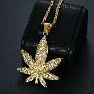 Gold plated hip hop necklace with iced out maple leaf pendant on black leather box