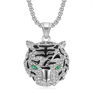 Détail du pendentif tête de tigre argenté avec cristaux blancs et yeux en gemme verte