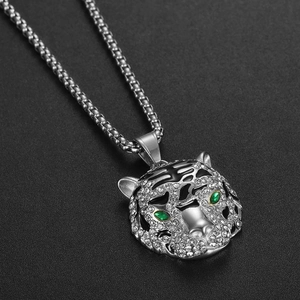 Vue détaillée du pendentif tête de tigre en argent avec yeux verts et rayures en émail noir