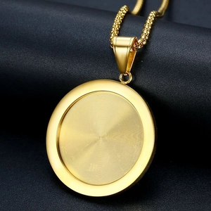 Vue détaillée du pendentif rond doré avec texture en spirale sur cuir noir