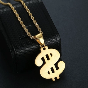 Close-up of gold dollar sign pendant with frosted texture on black jewelry box