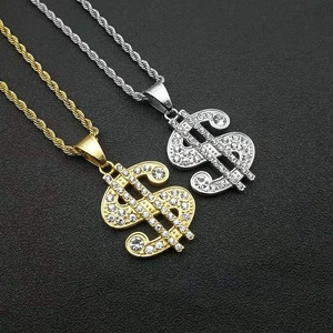 Close-up of gold and silver dollar sign pendants with paved rhinestones on twist chains