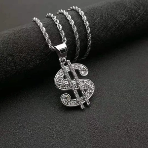 Macro detail of silver-toned hip hop dollar sign pendant with shimmering cubic zirconia