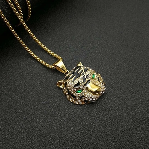Macro d'un pendentif léopard doré serti de cristaux blancs, yeux verts et émail noir